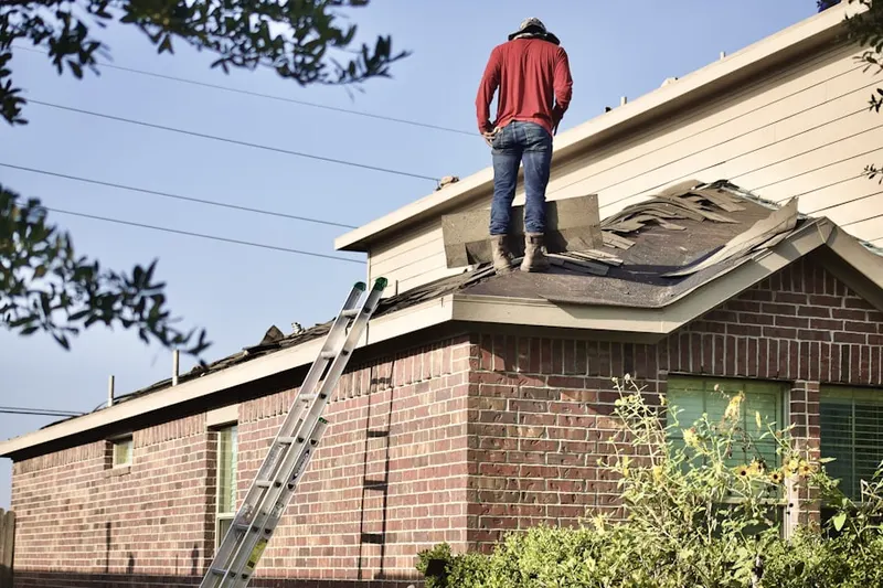 Professional roofer working on a residential roof in Ponquogue